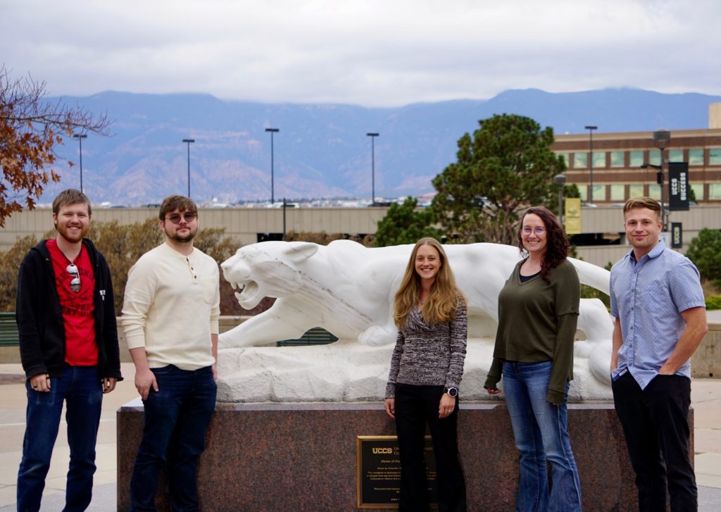 Team in front of UCCS mountain lion statue.